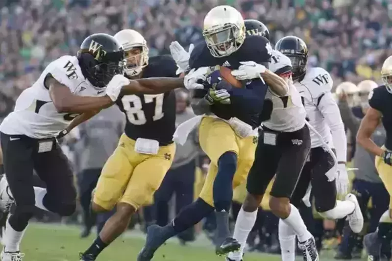 Running back Cierre Wood runs with the ball during a football game.